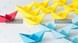 A group of paper boats sitting on top of the floor.
