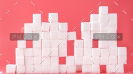 A pink background with sugar cubes stacked up.