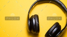 A pair of headphones on top of a yellow surface.