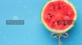 A watermelon cut in half with seeds on top of it.